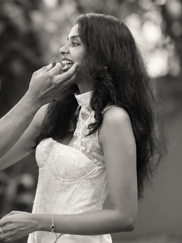 Aiswarya laughing in a white lace dress